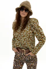 Blusa de corduroy de algodón con estampado floral en tonos mostaza y crudo, cuello a la base y mangas largas con hombros abullonados.
