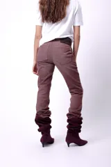 Jean de tiro medio color marrón, de corte recto y largo, con efecto arrugado en la parte inferior.