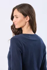 Saco tejido fino de hilo de algodón color beige, con cuello en V, cierre frontal con botones y puños acanalados.