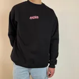 Buzo de cuello redondo y corte oversize, color blanco, con estampa gráfica en la espalda que repite la palabra 'Amore' en tonos rosados y un diseño central destacado en negro.