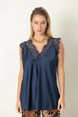Blusa azul marino de satén con escote en V y detalles de encaje en el escote y los hombros.