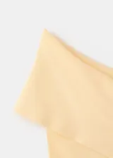 Top asimétrico de punto fino color amarillo pálido, con diseño de un solo hombro y corte recto ajustado al cuerpo.