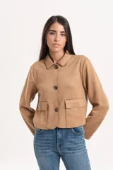 Chaqueta corta de simil gamuza color tostado, con cuello clásico, cierre frontal de botones y dos bolsillos delanteros con solapa.