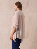 Camisa larga de rayón, con cuello clásico, cierre frontal con botones y mangas regulables con presilla. Presenta un diseño holgado con tajos laterales en el ruedo.