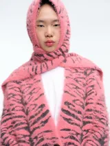 Bufanda de tejido de punto suave con diseño de estampado animal tipo cebra en tonos rosa y gris, que incluye una capucha integrada.