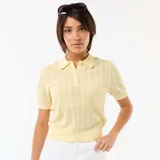 Remera de punto calado color amarillo, con cuello polo, manga corta y cierre frontal parcial con botones.
