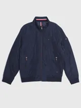 Campera bomber Tommy Hilfiger azul marino con cuello alto, cierre frontal con cremallera, dos bolsillos laterales con cremallera, puños y bajo elásticos. Tiene el logo de Tommy Hilfiger bordado en el pecho y un parche con el logo en la manga izquierda. El interior del cuello tiene detalles en rojo, blanco y azul.