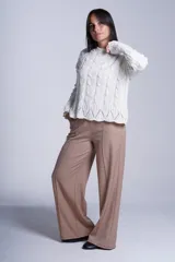Pantalón de corte amplio y tiro alto, color beige, con elástico en la cintura trasera, pinzas frontales marcadas y bolsillos laterales.