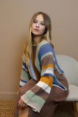 Sweater de algodón tejido a rayas horizontales en tonos tierra, azul y verde pastel, con cuello redondo y mangas largas acampanadas.