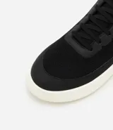 Championes Viko de hombre, color negro con suela blanca de EVA. Confeccionados en poliéster con recortes, cierre de cordones y puntera redondeada.
