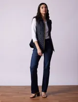 Chaleco capitoneado color beige, marca Gallery. Con abertura central con cierre, bolsillos delanteros con cierre, laterales en tejido elastizado y forro interno a tono.