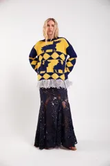 Sweater de lana merino tejido a mano con diseño geométrico y figuras de llamas, corte holgado con cuello redondo y flecos decorativos en el ruedo.