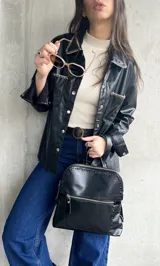 Sobrecamisa negra de cuero sintético con pespuntes en contraste y cierre con botones a presión.