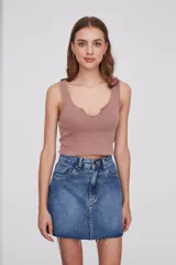 Top corto de punto acanalado color rosa viejo, con escote en U y terminación ondulada en el ruedo.