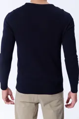 Buzo de punto con cuello redondo a la base, de manga larga y corte clásico, confeccionado en tejido de punto fino.