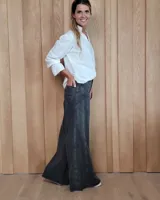 Pantalón de jean azul de tiro medio, con corte wide leg y ruedo deshilachado.
