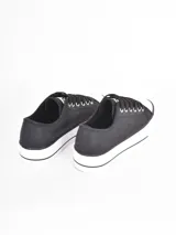 Zapatillas de plataforma estilo urbano, color negro con puntera y suela de goma blanca. Cuentan con cordones negros y ojales metálicos.