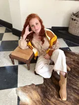 Sweater de punto con diseño geométrico en tonos mostaza, marrón y beige.