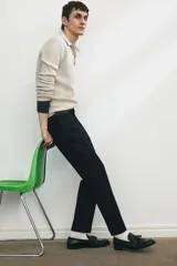 Pantalón de vestir negro, corte slim fit, con cierre y botón frontal, bolsillos laterales y bolsillos insertados traseros con botón. Presenta raya marcada en las piernas.