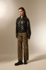 Campera de eco-cuero color negro, con cuello clásico, cierre frontal y puños con elástico. Presenta un diseño de corte holgado con costuras verticales decorativas.