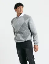 Sweater de punto con diseño de rombos en gris y azul marino, escote redondo a la base, manga larga y terminaciones en punto acanalado en cuello, puños y ruedo.