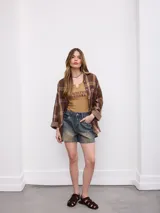 Camisa de flanela a cuadros en tonos marrones y azules, de corte oversize, con mangas largas y bolsillos frontales.