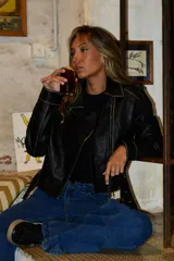 Chaqueta de cuero sintético marrón, tipo biker, con cierre frontal cruzado, solapas con muesca y bolsillos laterales con cierre.
