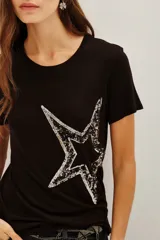 Remera negra de viscosa con cuello redondo y manga corta, presenta una estampa central de estrella grande decorada con lentejuelas brillantes.