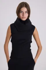 Chaleco negro de punto con cuello alto y diseño sin mangas.