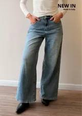Pantalón de jean con corte wide leg y tiro medio-alto. Presenta un lavado gris azulado desgastado con acabado vintage y ruedo desflecado.