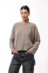 Remera de silueta amplia con hombro caído y cuello redondo, confeccionada en tejido suave de algodón. Presenta un diseño holgado y versátil con mangas largas.