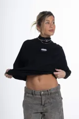 Remerón negro de manga ranglan, corte holgado, con cuello redondo y un pequeño logo estampado en el pecho.