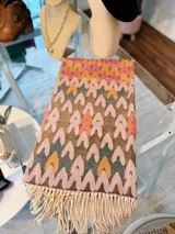 Pashmina rectangular con diseño de corazones entrelazados y flecos en los extremos.