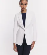 Blazer alargado slim de Cortelle, color blanco, confeccionado en punto roma con solapas, bolsillos embutidos y cierre delantero de dos botones.