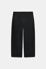 Pantalón de tiro medio con corte tipo ballon, bolsillos delanteros y detalle de pinzas. Cuenta con cierre frontal de cremallera y gancho metálico.