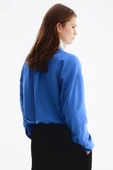 Camisa de lino y viscosa color azul, de corte oversized y diseño liviano, con cuello clásico, cierre frontal de botones, hombros caídos y mangas largas con puños abotonados.
