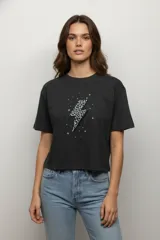 Remera de algodón color beige con cuello redondo y mangas cortas. Presenta un estampado frontal de dos cerezas con diseño de animal print de leopardo.