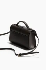 Cartera cruzada color marrón oscuro con acabado texturizado suave. Cuenta con asa superior, correa ajustable y solapa con cierre de mosquetón ovalado metálico.