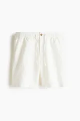 Short de corte regular fit en mezcla de algodón y lino color blanco, con cintura elástica, cordón ajustable, botón frontal, bolsillos laterales y bolsillos traseros ojalados.