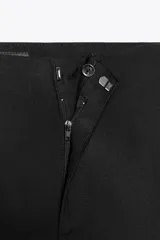 Pantalón blanco de tiro alto, corte ancho tipo flare, con cierre frontal de cremallera y gancho metálico.