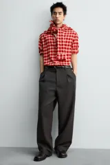 Camisa de corte relajado confeccionada en tejido de mezcla de viscosa y lana con acabado de franela. Presenta un diseño de cuadros en tonos rojo y beige, cuello con botones, cierre frontal de botones y mangas largas con puños abotonados.