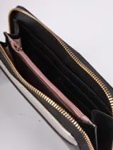 Billetera negra de símil cuero con cierre perimetral. Tiene dos compartimentos, espacio para ocho tarjetas, efectivo y un bolsillo con cierre para monedas.
