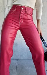 Pantalón de cuero sintético color rojo, de corte recto y tiro alto, con costuras blancas a contraste.