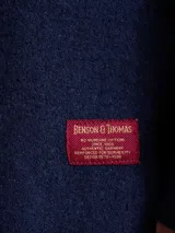 Overshirt de tejido de punto color azul marino, con cuello camisero, cierre frontal de botones y dos bolsillos frontales tipo parche.