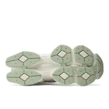 Championes New Balance modelo 9060 de estilo chunky, confeccionados con una combinación de gamuza y malla en tonos beige, blanco y detalles en verde menta pálido. Presentan una suela robusta esculpida y el característico logotipo "N" en los laterales.