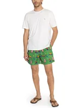 Short de baño de secado rápido con estampado de guacamayos sobre fondo verde. Cuenta con cintura elástica, cordón ajustable, bolsillos laterales y bolsillo trasero.