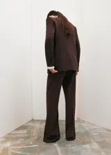 Pantalón de vestir marrón con sutil estampado de rayas diplomáticas en tono más claro, corte recto y largo.