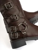 Bota marrón de caña alta con hebillas metálicas decorativas.