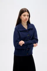 Cardigan de punto con diseño de ochos, color azul marino, con cuello solapa, cierre frontal con botones y mangas largas con puños acanalados.