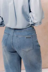 Pantalón de jean de tiro alto, corte culotte y pierna ancha, color azul medio con lavado desgastado.